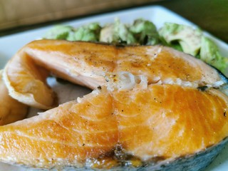 Salmon steak with avocado garnish. A high-fat, low-carb keto-diet