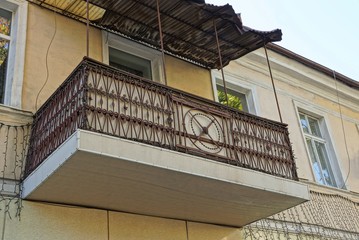 one old brown metal and concrete balcony on the wall with windows