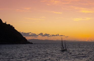 Sailboat on the coast of the city of Donostia with the last rays of the sun at sunset, Cantabrico Sea, Euskadi