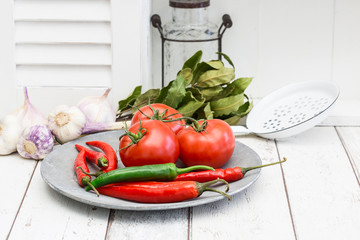 Rustic Plate With Red Tomatoes And Hot Chilly Across White Kitchen Area