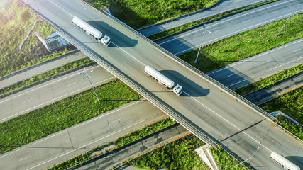 Gasoline fuel trucks caravan driving by the highway road. Top view from drone.