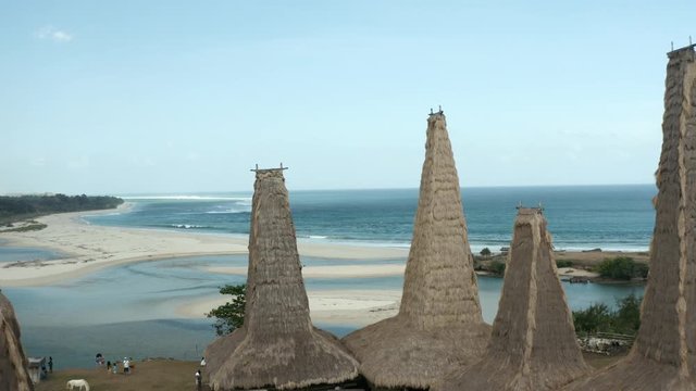 Forward drone shot above the traditional Ratenggaro Village, Sumba, with the ocean in the background