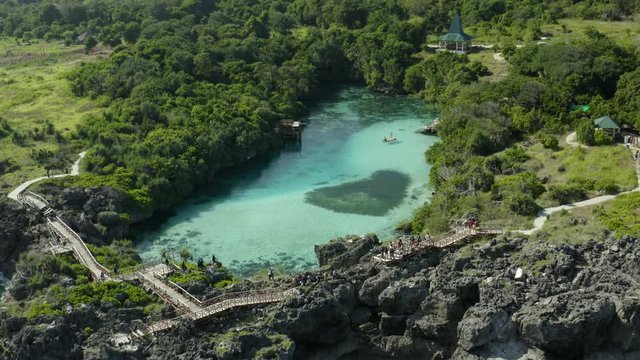 Backward drone shot above Weekuri Lake, Sumba, in front of the ocean