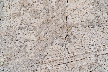 The texture of a concrete wall. Surface with scratches, scuffs, cracks. Gray color of surface. Background
