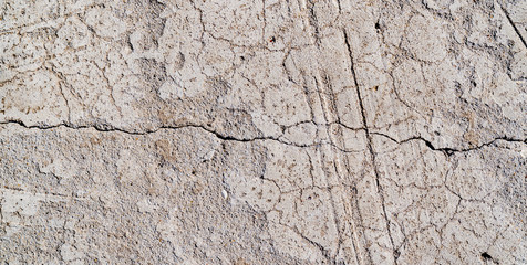 The texture of a concrete wall. Surface with scratches, scuffs, cracks. Gray color of surface. Background