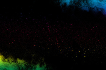 Fototapeta na wymiar Multi colored powder explosion on black background.Colorful dust splash cloud on dark background.