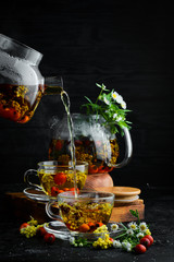 Chamomile and wild rose tea. Hot winter drinks. On a black background. Top view.