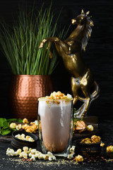 Cocoa with milk and popcorn. In the glass. Top view. On a black background.