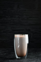 Cocoa with caramel and milk. In the glass. Top view. On a black background.
