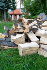 Pile of firewood prepared to heating house in the background