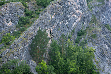 View of the mountain sheer ridge with the entrance to the cave