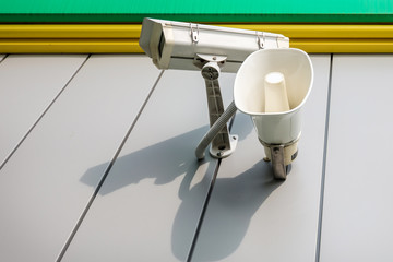 outdoor surveillance and tracking security camera with a megaphone on the wall of building