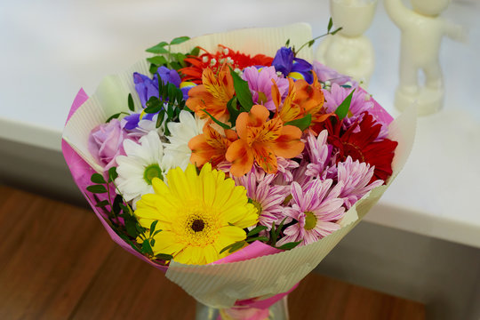 Decorated colorful flower bouquet. Yellow Gerbera, Pink Chrysanthemum, Blue Irises, Pink Rose, Orange Alstroemeria
