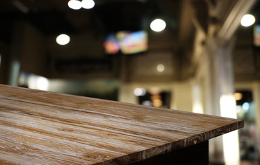 Empty dark wooden table in front of abstract blurred bokeh background of restaurant . can be used for display or montage your products.Mock up for space.