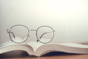 Reading thin frame glasses on book. Vintage style.