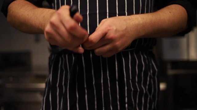 Hands Tying An Dark Apron Around The Waist Front View. Preparing And Cooking Food With Chef.