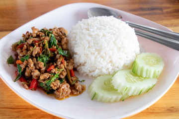 Stirred fried sea bass or white snapper with basil topped on rice on black dish