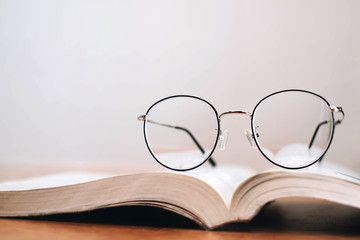 Reading thin frame glasses on book. Vintage style.
