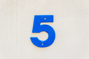 Number 5, five, street number sign on the wall	