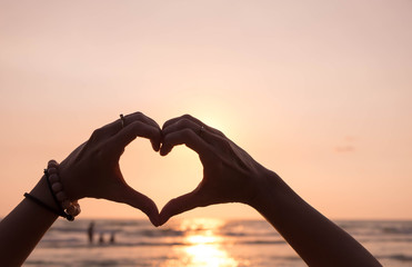 "Love sign" ,hand heart symbol in afternoon sunset sky.