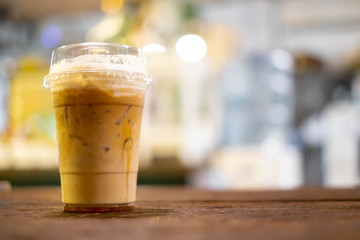 Ice cafe latte coffee the refreshment cold drink on wooden table with restaurant shop bokeh background.