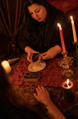 Fortune teller woman in dark room with lots of candles Gives an explaination of future and...