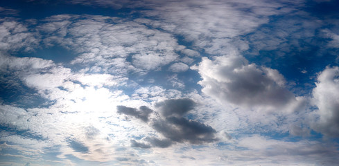 Blue sky with clouds and sun in late September background.