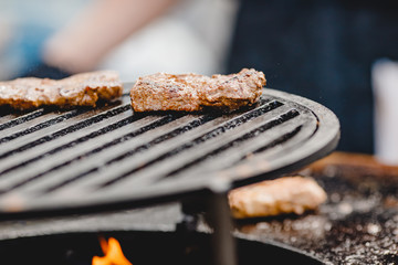 Pork ribs and steak cooked on grill, open fire street food festival