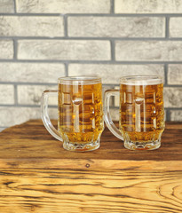 Two glasses of light beer on wooden table. 