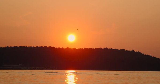 Majestic summer sunset lake hang glider