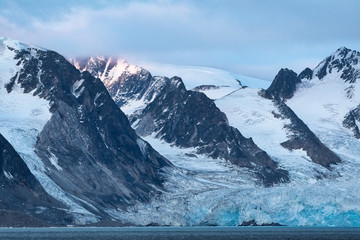 Svalbard mountain with iceberg and sea