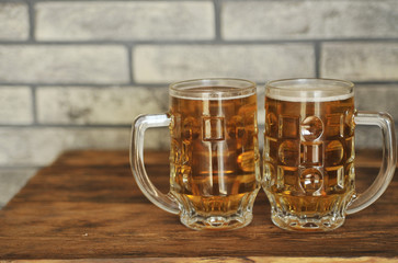 Two glasses of light beer on wooden table. Oktoberfest concept.