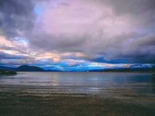 Photo of norway with sea, cloudy sky on summer evening .