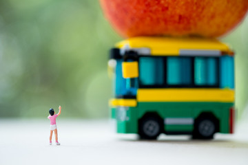 Miniature people : Children going to school by school bus in the first time.