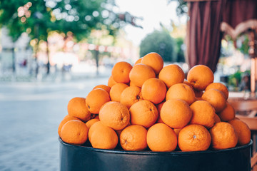 Sale of big fresh natural organic oranges on the city street. Citrus harvesting season. Making of orange fresh juice on the street.