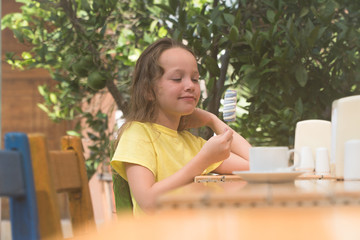 Fototapeta na wymiar girl eating ice cream at a table on the street.