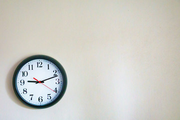 Black clock showing 9.10 o'clock on the wall with Copy Space. Soft focus process.