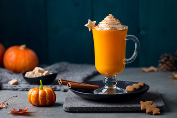 Pumpkin latte with spices. Boozy cocktail with whipped cream. Grey background. Copy space. Close up.