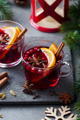 Mulled red wine with spices. Christmas decoration. Grey stone background.