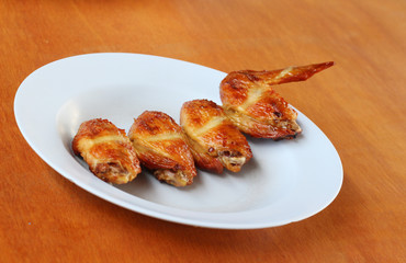 Roasted chicken in plate on wood