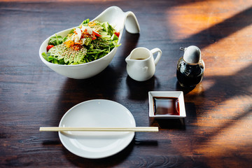 Japanese salad with avocado, tomato, green oak, almond and sesame topping sesame salad dressing.