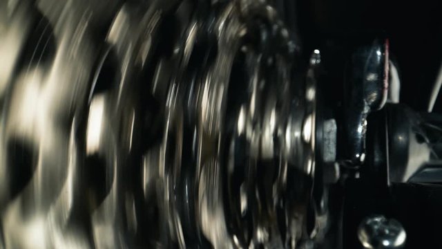 Close-up on rear bike cassette rotating with chain and changing gear
