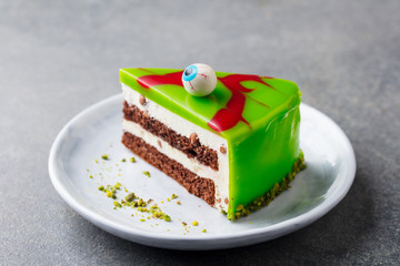 Halloween cake on a white plate with holiday table decoration. Grey background. Close up.