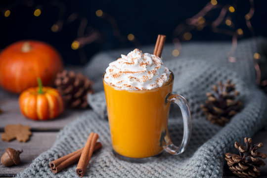 Pumpkin latte with spices. Boozy cocktail with whipped cream on top on a grey background.
