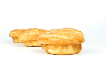 Three golden yellow Asian baking buns isolated on white background