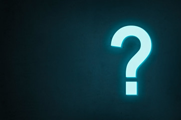 Neon question mark glows on a dark background, the concept of finding the answer to a question or finding a solution.
