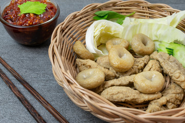 Meatballs with spicy sauce in basket on table.