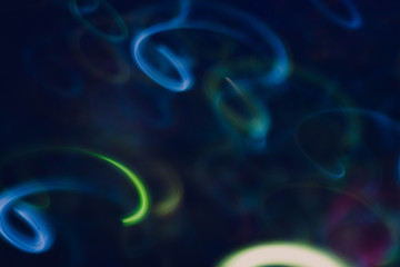 Neon blue and green lights. Blur glowing swirly lines. Dark abstract art background.