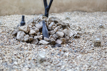 An interesting artistic composition of stones, branches and bottles.