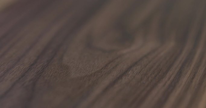 Closeup dolly slide over natural black walnut wood board with oil finish